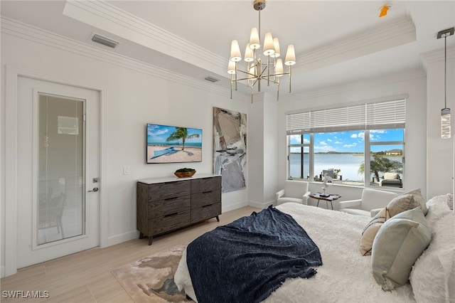 bedroom featuring a tray ceiling, ornamental molding, and an inviting chandelier