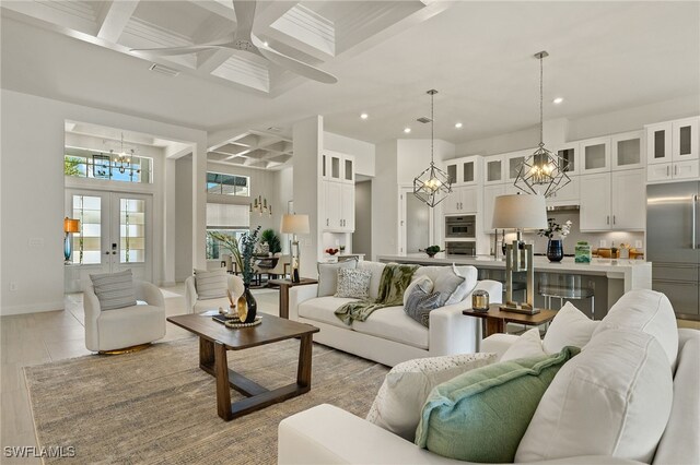 living room with beam ceiling, french doors, ceiling fan, and coffered ceiling