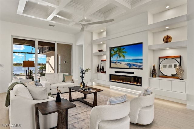 living room with coffered ceiling, a water view, ceiling fan, built in features, and beam ceiling