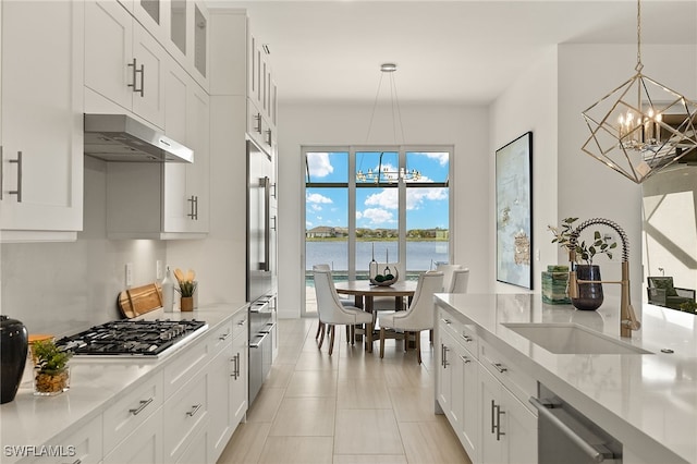 kitchen with pendant lighting, a water view, white cabinetry, and appliances with stainless steel finishes