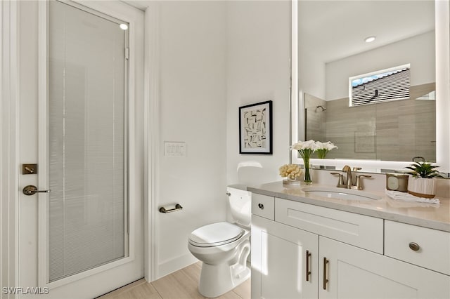 bathroom with vanity, an enclosed shower, and toilet