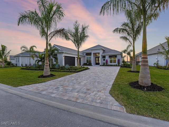 view of front of house with a yard and a garage