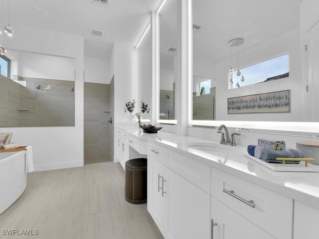 bathroom featuring a tile shower and vanity