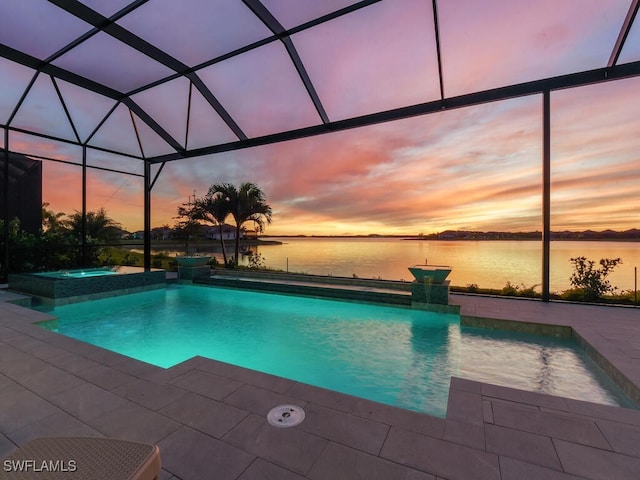 pool at dusk with a lanai, a patio area, a water view, and an in ground hot tub