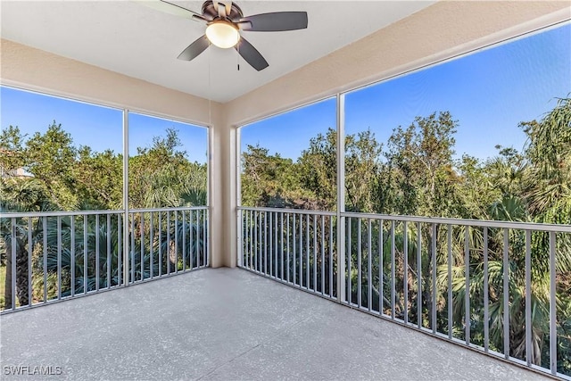 unfurnished sunroom with ceiling fan