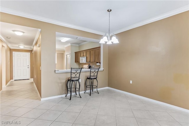 kitchen with an inviting chandelier, crown molding, decorative light fixtures, and kitchen peninsula