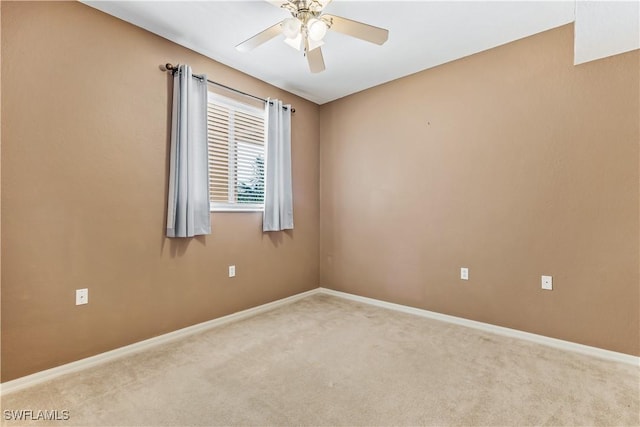 spare room featuring light colored carpet and ceiling fan