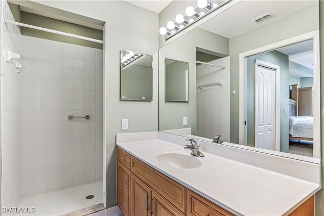 bathroom featuring a tile shower and vanity