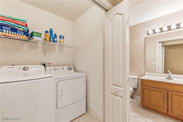 laundry room with washing machine and dryer, sink, and light tile patterned floors