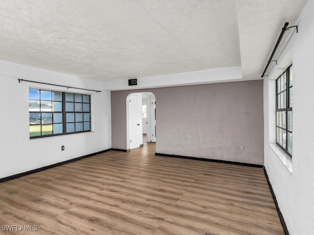 unfurnished room featuring wood-type flooring and a textured ceiling