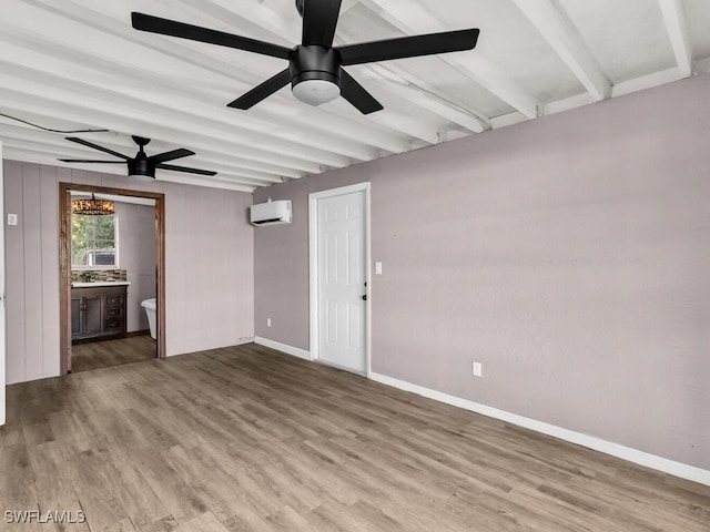 spare room featuring hardwood / wood-style floors, ceiling fan, beamed ceiling, and a wall unit AC