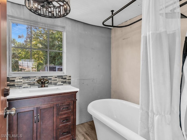 bathroom featuring backsplash, hardwood / wood-style flooring, a bathtub, and sink