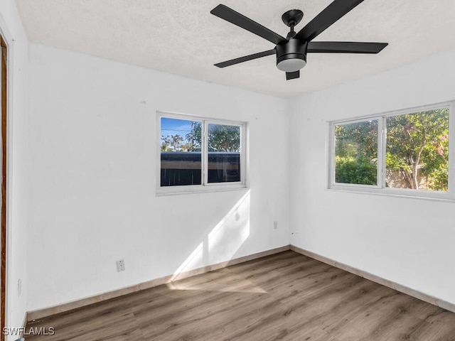 spare room featuring hardwood / wood-style flooring, plenty of natural light, and ceiling fan