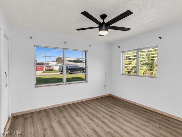 empty room featuring a textured ceiling, light hardwood / wood-style flooring, and ceiling fan