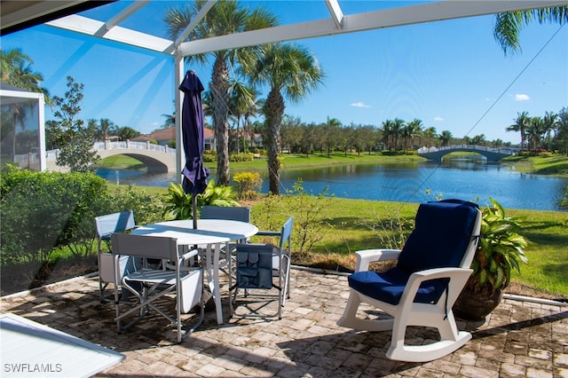 view of patio / terrace featuring a lanai and a water view