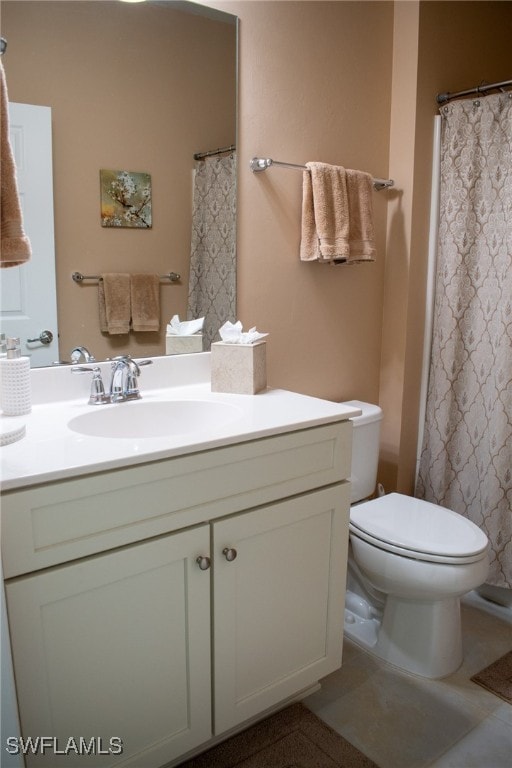 bathroom with tile patterned flooring, vanity, and toilet