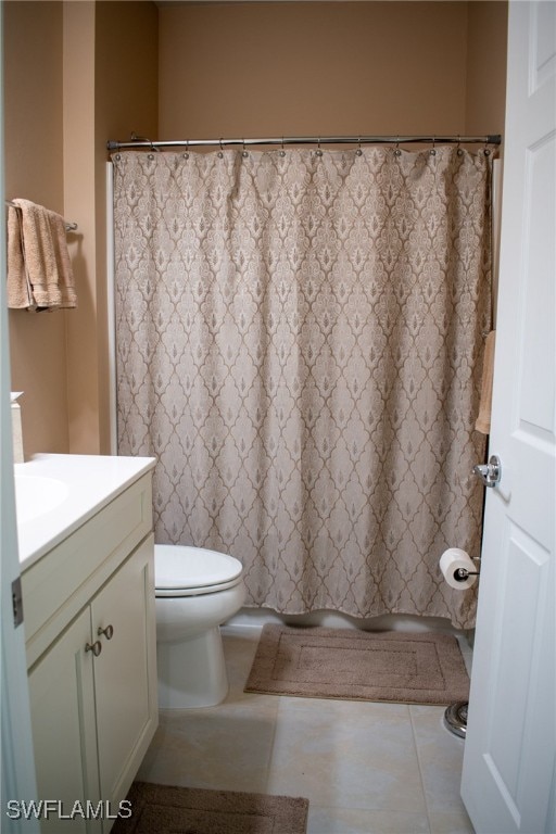 bathroom with tile patterned flooring, vanity, and toilet