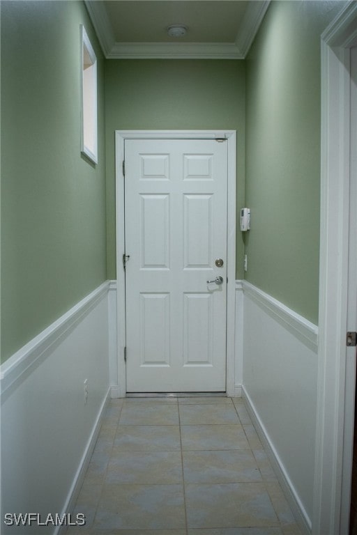 doorway to outside with crown molding and light tile patterned floors