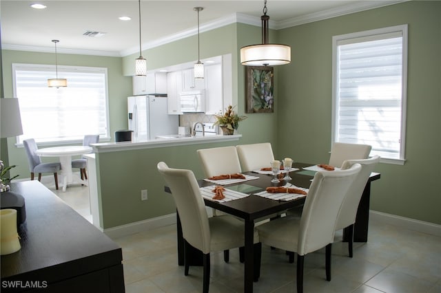 dining area with plenty of natural light, light tile patterned flooring, and crown molding