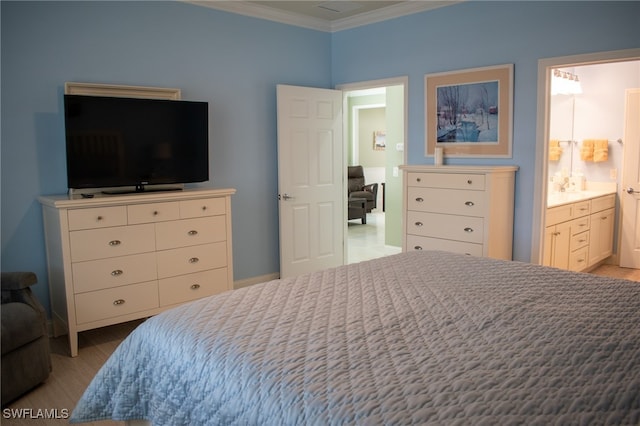 bedroom featuring crown molding and ensuite bath