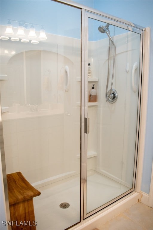 bathroom with an enclosed shower and tile patterned flooring