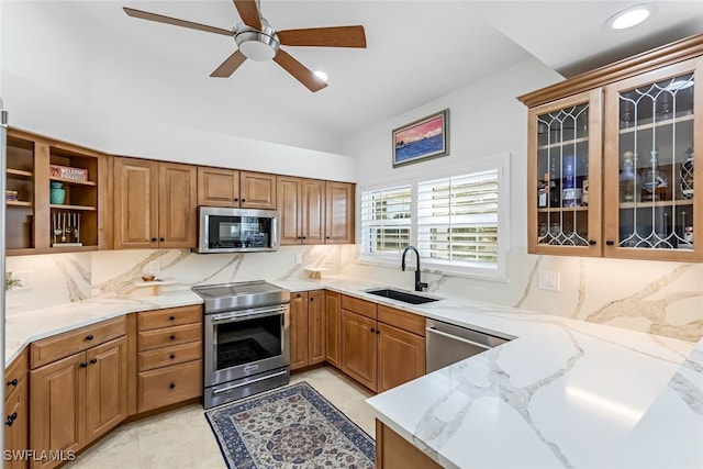 kitchen featuring sink, tasteful backsplash, light stone countertops, and stainless steel appliances