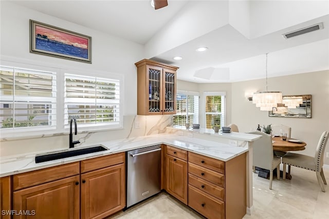 kitchen with light stone countertops, decorative light fixtures, sink, kitchen peninsula, and stainless steel dishwasher