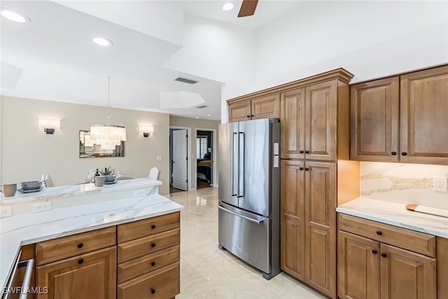 kitchen featuring light stone counters, hanging light fixtures, high end refrigerator, and ceiling fan