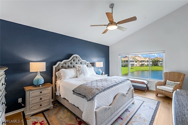 bedroom featuring ceiling fan, a water view, high vaulted ceiling, and hardwood / wood-style flooring