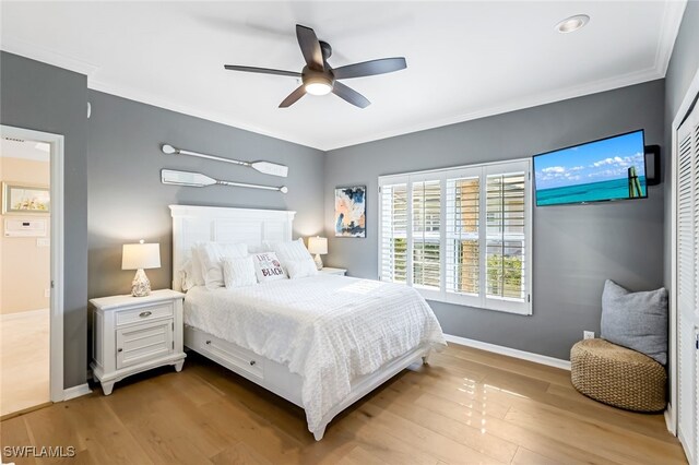 bedroom with crown molding, light wood-type flooring, and ceiling fan