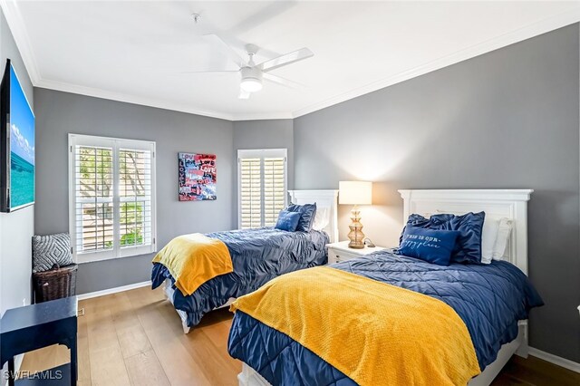 bedroom featuring ceiling fan, ornamental molding, and wood-type flooring