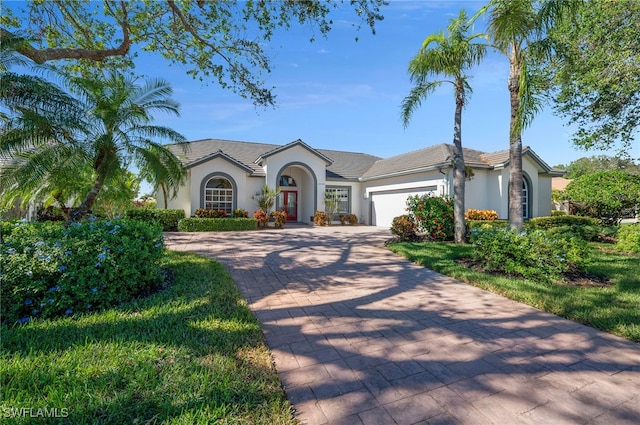 view of front of property with stucco siding, decorative driveway, and a garage