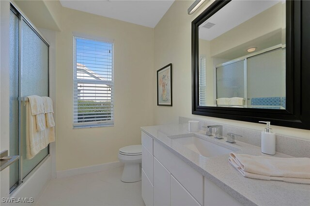 full bathroom featuring tile patterned flooring, vanity, toilet, and shower / bath combination with glass door