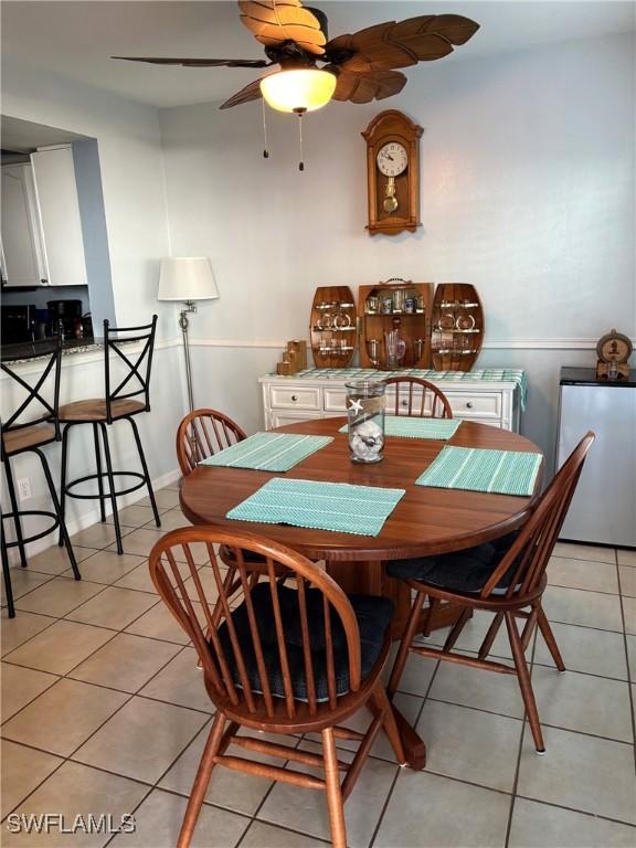 dining space with light tile patterned floors and ceiling fan