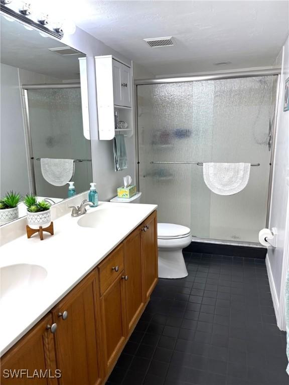 bathroom with toilet, vanity, and walk in shower