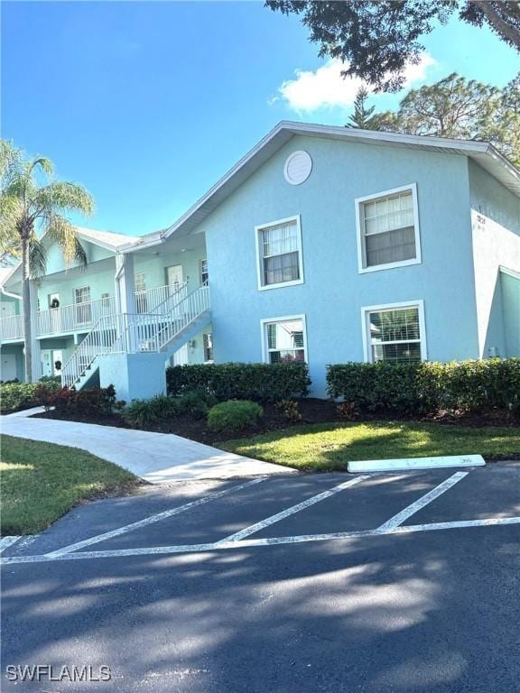 28230 Pine Haven Way Unit 68, Bonita Springs, FL 34135 - view of building exterior featuring stairway and uncovered parking