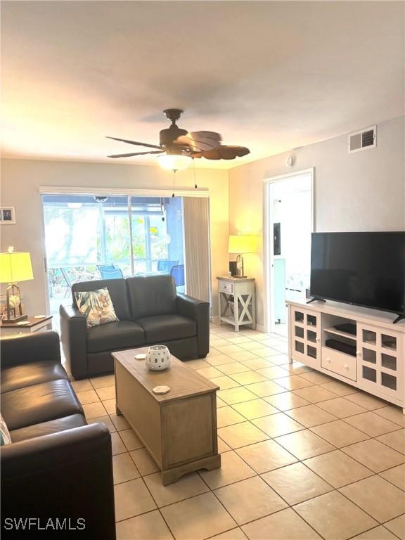 living room with ceiling fan and light tile patterned flooring