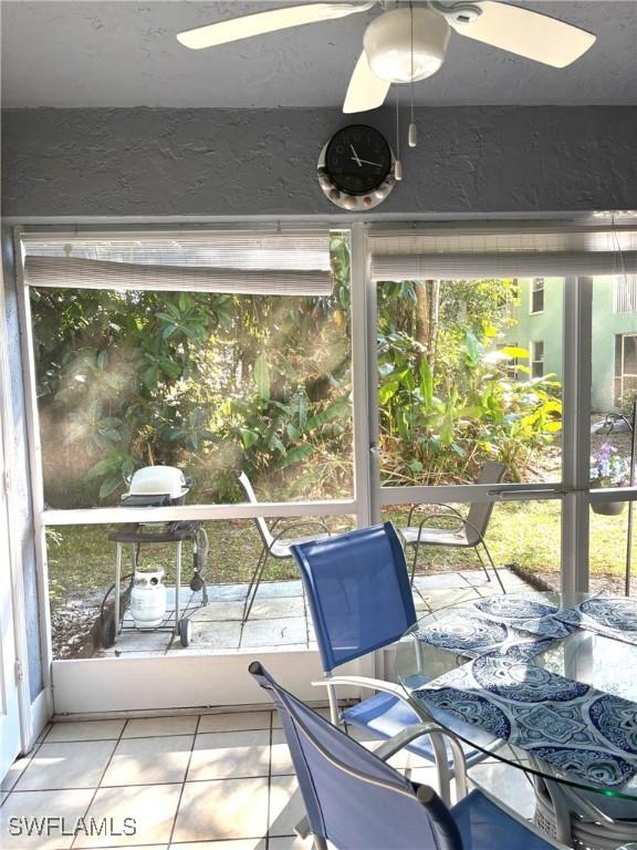 unfurnished sunroom featuring ceiling fan