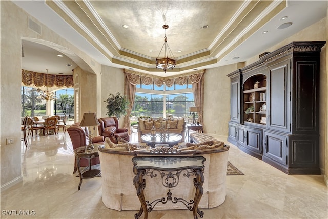 dining area with a tray ceiling, crown molding, and a chandelier