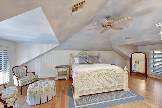 bedroom with ceiling fan, wood-type flooring, and lofted ceiling