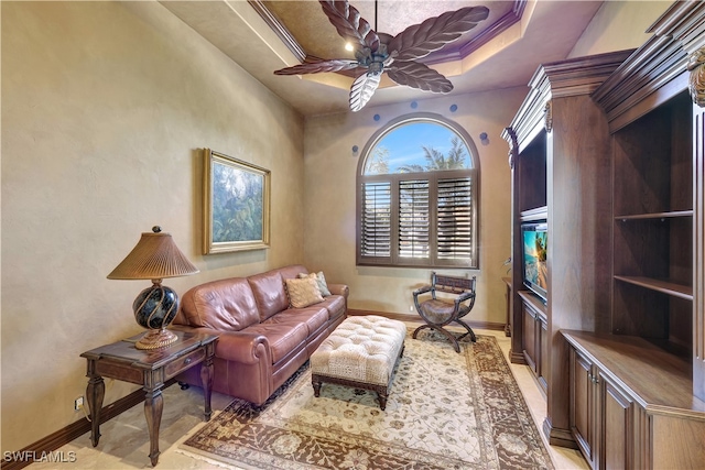 living room featuring ceiling fan, crown molding, and a tray ceiling