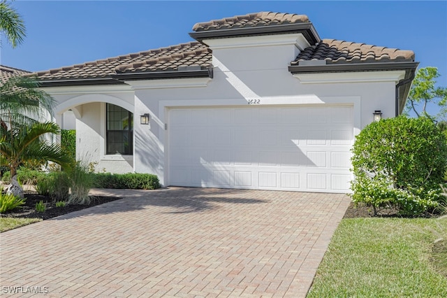 mediterranean / spanish-style house with a garage