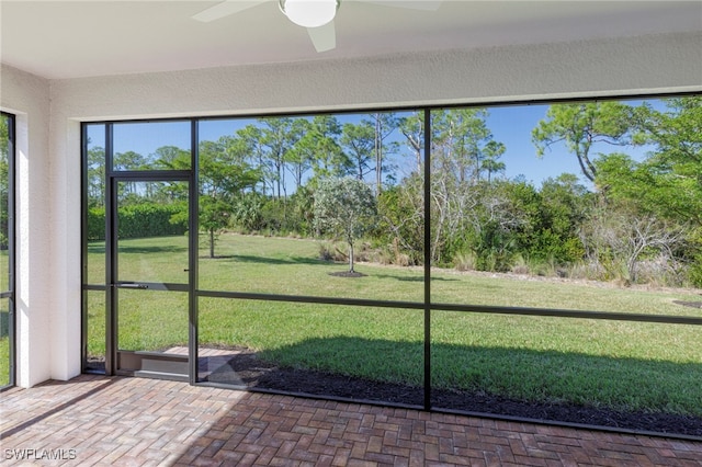 unfurnished sunroom featuring ceiling fan