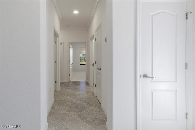 hall with light tile patterned flooring and ornamental molding