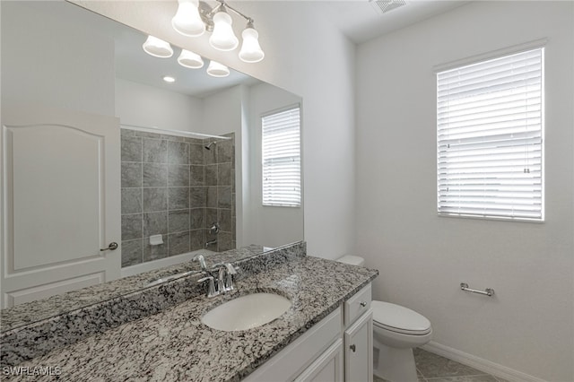 bathroom featuring tile patterned floors, plenty of natural light, toilet, and vanity