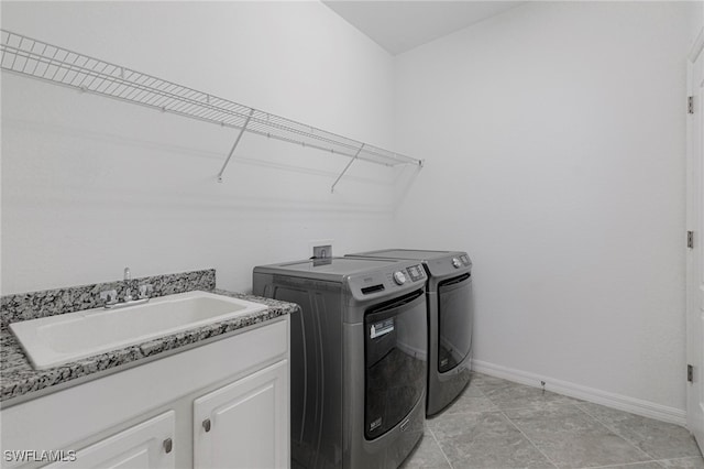 clothes washing area featuring sink, light tile patterned floors, cabinets, and independent washer and dryer