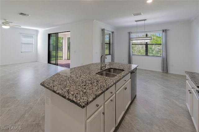 kitchen with stone counters, white cabinetry, sink, stainless steel dishwasher, and a center island with sink