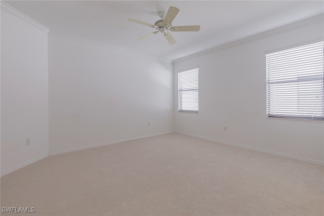 empty room with light colored carpet, ceiling fan, and crown molding