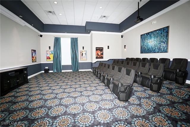 carpeted cinema room with a paneled ceiling and a high ceiling