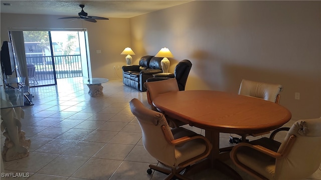 dining space featuring light tile patterned floors, a textured ceiling, and ceiling fan